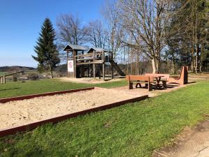 a park with a playground with a bench and a slide at Ferienwohnung Bergzeit mit Sauna und Pool in Sankt Englmar