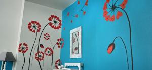 a room with blue walls with red flowers on the wall at Au Domaine de PY in Le Valtin