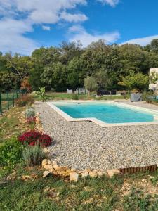 a swimming pool in a landscaped yard with a garden at Le Petit Chêne in Orgnac-lʼAven
