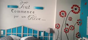 a bedroom with a bed and flowers on the wall at Au Domaine de PY in Le Valtin