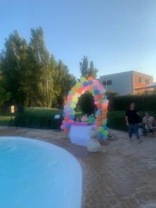 a rainbow colored balloon arch next to a pool at Tenuta Monaci La Murra in Carmiano