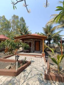 a small house with a porch and a building at Ellora Heritage Resort in Ellora