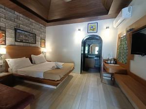 a bedroom with a bed and a sink and a tv at Ellora Heritage Resort in Ellora