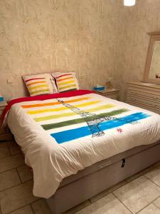 a bed with a colorful blanket on top of it at Villa Lucienne in Comines