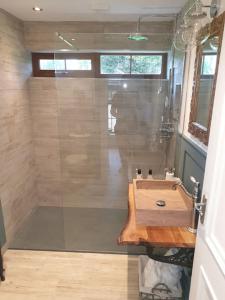 a bathroom with a shower with a sink and a glass shower at St Patrick's Cottage in Saul +24 photos