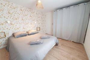 a bedroom with a bed with two pillows on it at Le Doré Rose by Madame Conciergerie in Bruz