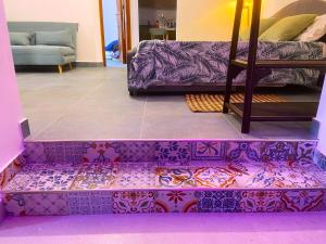 Sala de estar de color púrpura con sofá y mesa en Gelsomino Sea View Suite & Spa en San Vito lo Capo