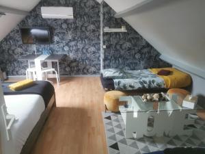 uma sala de estar com duas camas e uma mesa em Agréable chambre d’hôte à la campagne em Villefranche-Sur-Cher