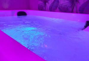bañera de hidromasaje en una habitación rosa con agua en Gelsomino Sea View Suite & Spa en San Vito lo Capo