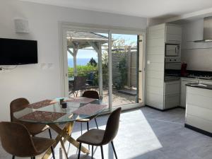 a kitchen and dining room with a glass table and chairs at Chez Jean Claude la villa des amis in Olmeto