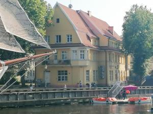 a couple of cars in the water in front of a building at Aparthotel Stora Antis in Klaipėda