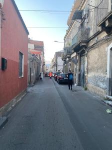 osoba idąca ulicą w alejce w obiekcie Cucchiara apartment w Katanii