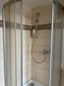a shower with a glass door in a bathroom at My easy home in Hamburg