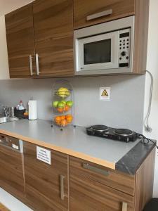 a kitchen counter with a microwave and a bowl of fruit at My easy home in Hamburg
