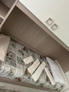 uma cama com duas almofadas e um jornal em Teate Apartments em Chieti