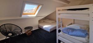 Cette chambre comprend 2 lits superposés et un ventilateur. dans l'établissement Le Petit Nord, à La Panne