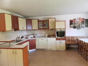 cocina grande con armarios blancos y mesa en APARTMA BREST, en Gornji Grad