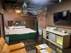 a bedroom with a large bed and a flat screen tv at エリア５１ in Kishimoto