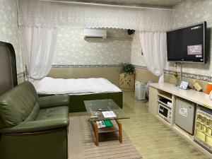 a small room with a bed and a couch and a table at エリア５１ in Kishimoto