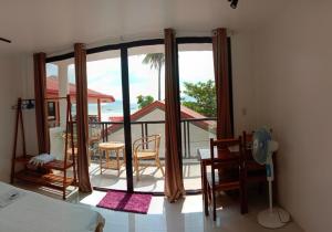 a bedroom with a view of a balcony at Corong Beach Resort in El Nido