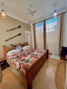 a bedroom with a large bed and a window at VICK Boutique Hotel with NEW power backup in Nungwi