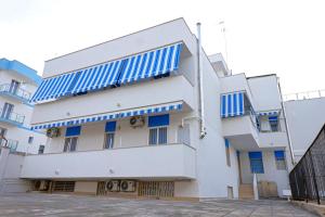 ein weißes Gebäude mit blauen Streifen darauf in der Unterkunft Stella di Mare GuestHouse in Bari