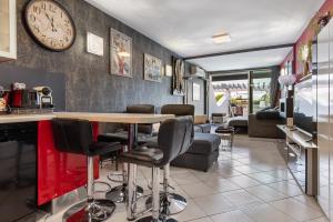 salon ze stołem i zegarem na ścianie w obiekcie appartement village naturiste port ambonne w Cap d'Agde