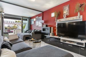 salon z czerwonymi ścianami i telewizorem z płaskim ekranem w obiekcie appartement village naturiste port ambonne w Cap d'Agde