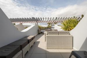 balkon z wiklinowymi siedziskami i widokiem na niebo w obiekcie appartement village naturiste port ambonne w Cap d'Agde