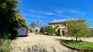 uma casa velha com um pequeno galpão no quintal em Beachborough Country House em Barnstaple