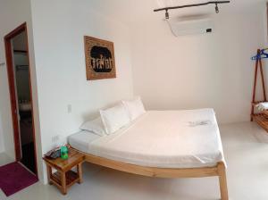 een slaapkamer met een bed met witte lakens en een spiegel bij Corong Beach Resort in El Nido