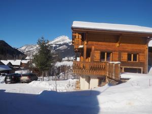 a log cabin with a balcony in the snow at LATITUDE 47 in Châtel