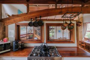 a kitchen with a stove and two windows at The Floating Forest in Denmark