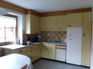 una cucina con armadi in legno e frigorifero bianco di Apartment Telser a Lasa