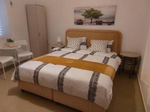 um quarto com uma cama grande com uma mesa e cadeiras em המקום של כרמית em Neve Zohar