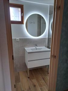 ein Bad mit einem Waschbecken und einem Spiegel in der Unterkunft Lac de Naussac in Langogne