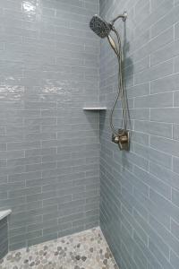 een badkamer met een douche met blauwe tegels bij Watershed Cottage in Mexico Beach
