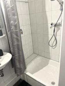 y baño con ducha y lavamanos. en Gemütliches zentrales Apartment 2 min bis DU HBF en Duisburg