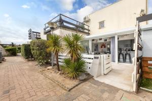 Dieses weiße Haus verfügt über eine Küche und eine Terrasse. in der Unterkunft VILLA PORT NATURE village naturiste in Cap d'Agde