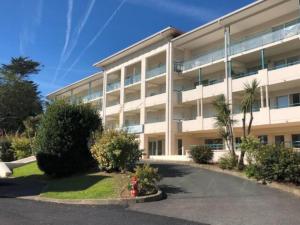 ein großes Gebäude mit einem Parkplatz davor in der Unterkunft Studio au calme avec piscine, face golf, parking gratuit, tout à pied à 10mn centre ville in Ciboure