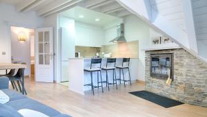 cocina y sala de estar con chimenea de piedra en Saplan Real Estate PIJAUERT en Les