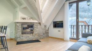 sala de estar con chimenea de piedra y TV en Saplan Real Estate PIJAUERT en Les
