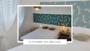 una camera da letto con un letto con una parete verde di La maison rouge paisible maison de pays a Saujon Altre 8 foto