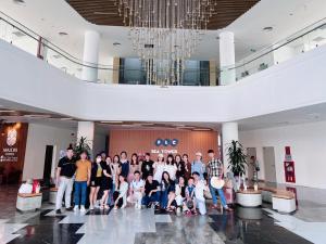 a group of people posing for a picture in a lobby at FLC Sea Tower Quy Nhon -Tran Apartment in Quy Nhon