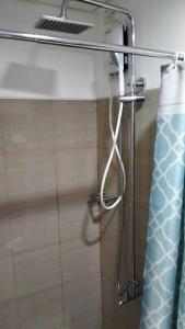 een douche in een badkamer met een douchegordijn bij Shore 1 Residence Tower C2 - MOA in Manilla
