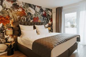 a bedroom with a large bed with a floral wallpaper at Blumen(t)raum - Ferienwohnung in Karlsruhe in Karlsruhe