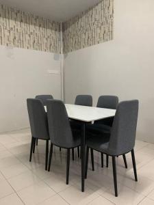 Homestay 69 في Hutan Melintang: طاولة بيضاء وكراسي في غرفة