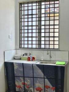 a kitchen with a sink and a window at Homestay 69 in Hutan Melintang