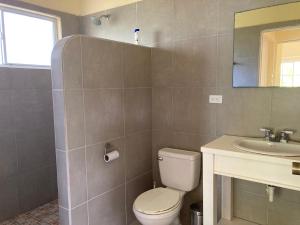 a bathroom with a toilet and a sink at Sunhill Villa in Big Corn Island