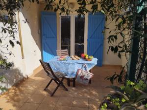 una mesa con un mantel azul en el patio en Le Surplage, en Hyères